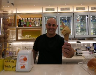 Een man reikt eigen gelato aan