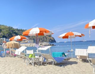 Strand van Ischia met parasols en ligstoelen