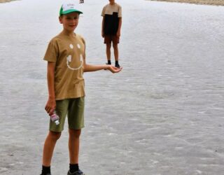 Kinderen op Badwater Basin zoutvlakte in Death Valley